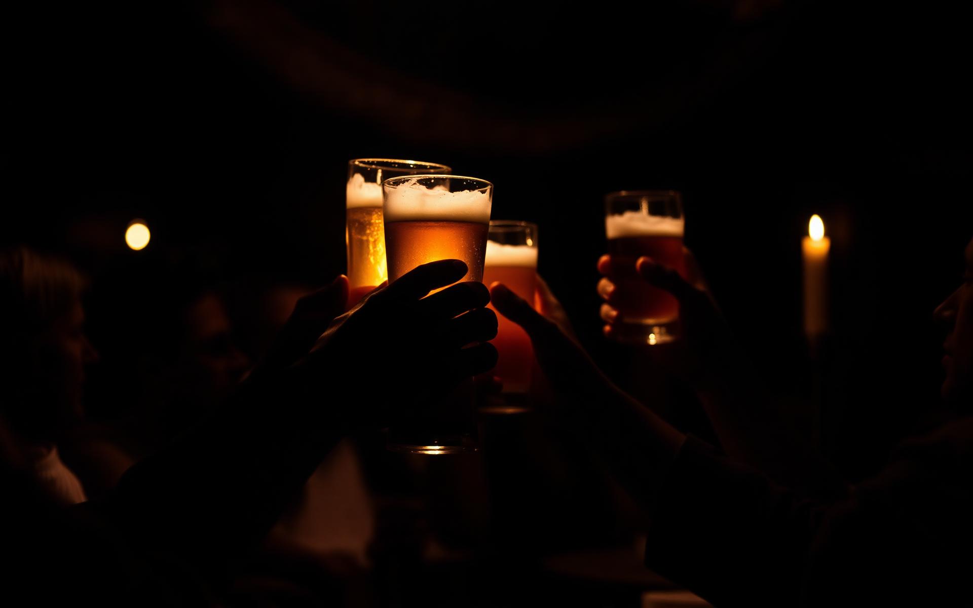 Raised glasses in candlelight